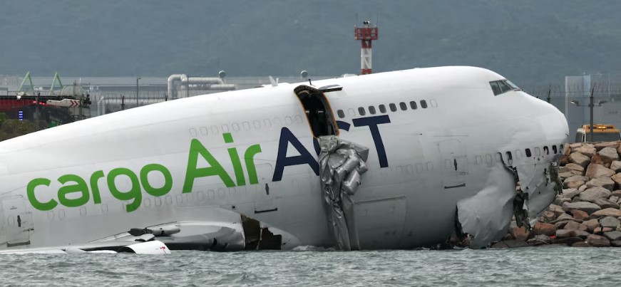 Two Hong Kong airport security staff were killed early on Monday after a cargo plane from Dubai skidded off the runway on landing, collided with their security patrol vehicle and pushed it into the sea, the city's airport operator said.