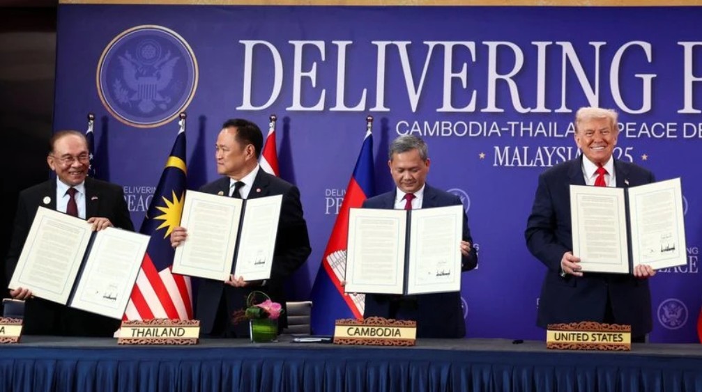 Malaysia's PM Anwar Ibrahim, Thailand's PM Anutin Charnvirakul, Cambodia's PM Hun Manet and US President Donald Trump hold up documents during the signing of a ceasefire deal between Cambodia and Thailand.