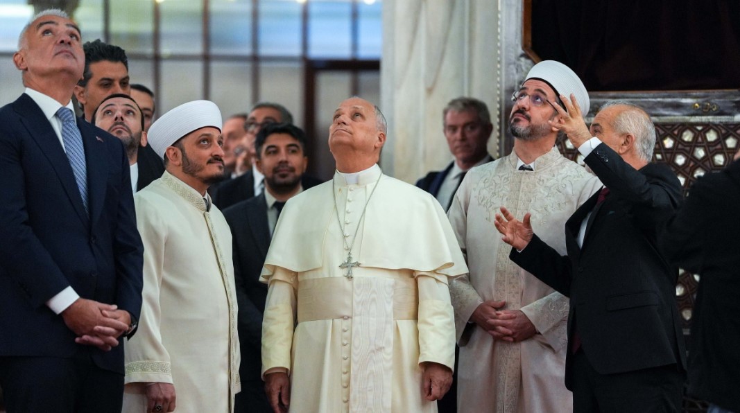 Pope Leo XIV looks up at the ceiling of the Sultan Ahmed Mosque, more commonly called the Blue Mosque, in Istanbul during a visit Nov. 29, 2025. Kurra Hafiz Fatih Kaya, the imam of the mosque, is to the right of the pope; Emrullah Tuncel, the mufti of Istanbul, is to the left of the pope; and Askin Musa Tunca, the mosque’s muezzin, wearing a suit and tie, is guiding the visit.