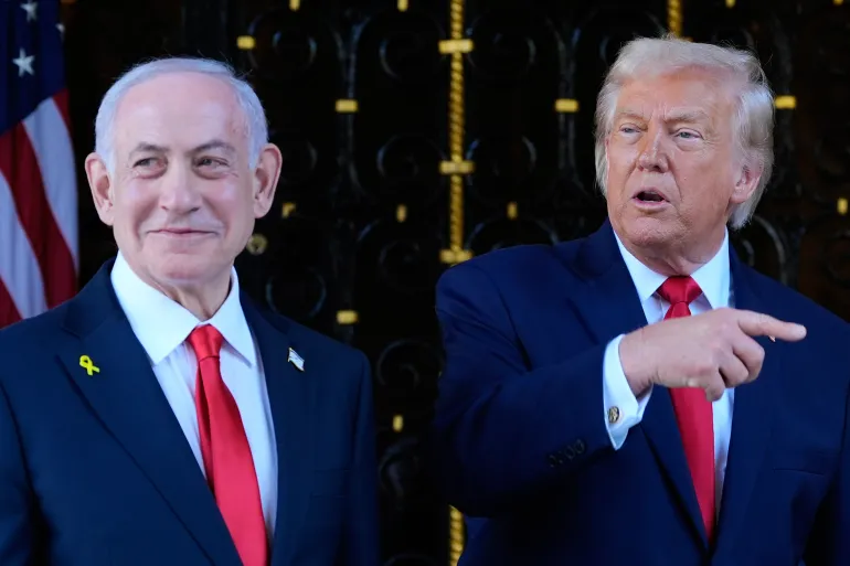 Photo of Trump speaking to reporters | Caption: US President Donald Trump announces a five-day pause on Iranian power plant strikes, March 24, 2026.